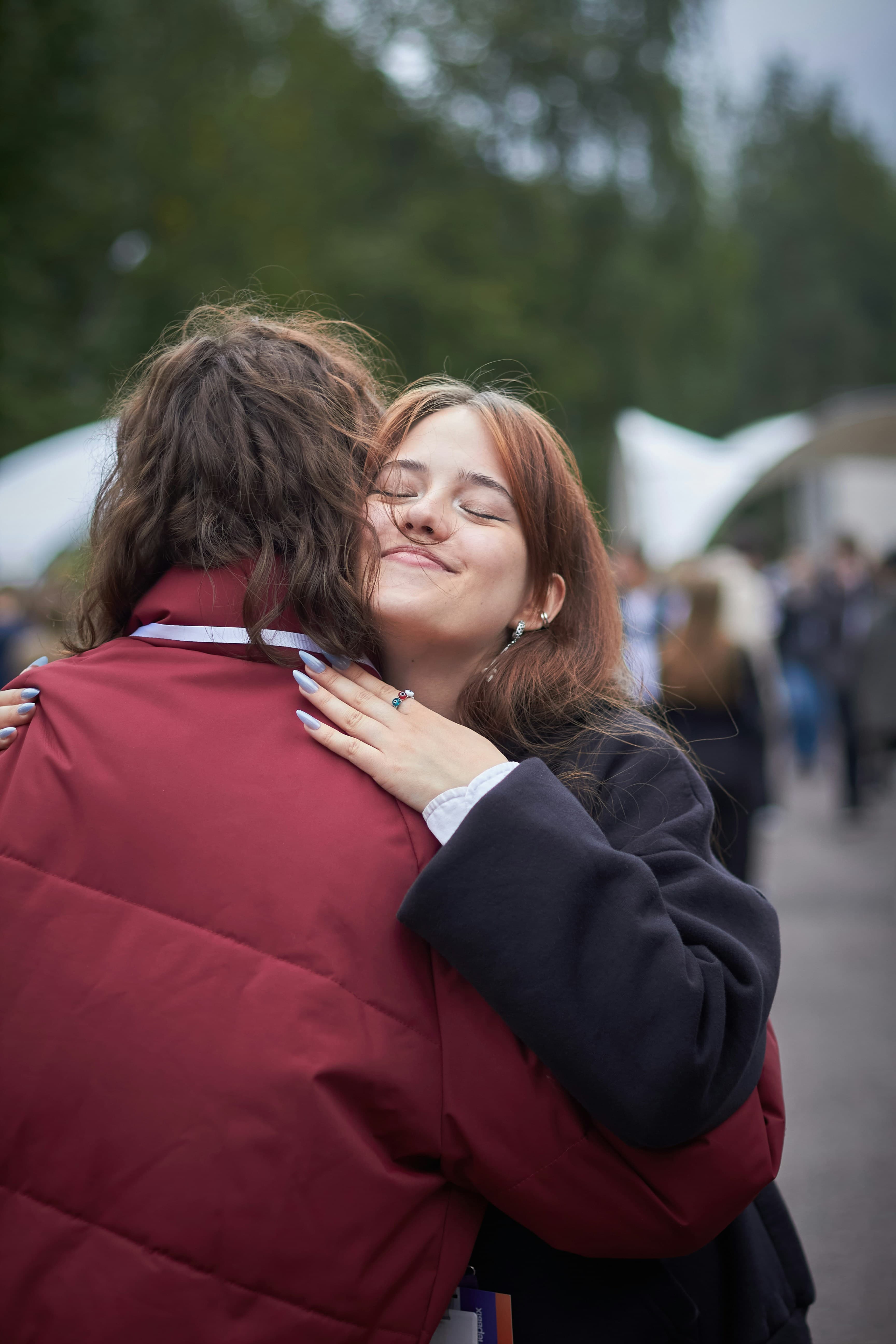 Two friends embracing in a warm hug outdoors